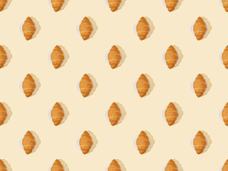 top view of fresh croissants on beige, seamless background pattern