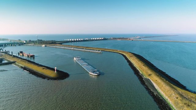 Enclosure Dam (Afsluitdijk): Large Cargo Ship with the Enclosure Dam Behind It, Zooming Out Overview - Friesland, Netherlands / Holland &ndash; 4K Drone Footage