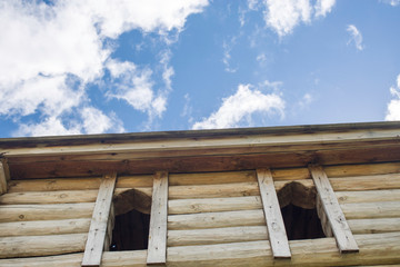 bottom view of a wooden tower of an old fortress on a background of clouds
