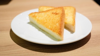 Selective focus of yellow or brown Grilled toast bread slices on white dish for breakfast