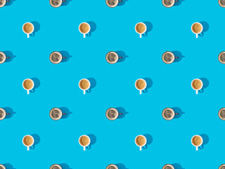 top view of cups of fresh coffee on blue, seamless background pattern