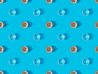 top view of cups of fresh coffee and glasses of water on blue, seamless background pattern