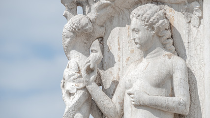 Fototapeta premium Ancient aged sculpture of beautiful Eva with an apple taken from a snake from the Bible story at Doge Palace in Venice, Italy