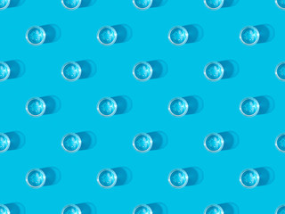 top view of glasses of water on blue, seamless background pattern