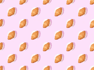 top view of croissants on plates on pink, seamless background pattern