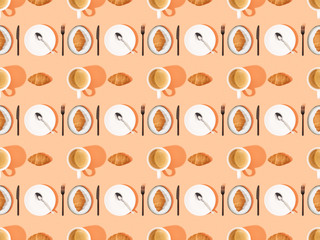 top view of cutlery, fresh croissants on plates and coffee on orange, seamless background pattern