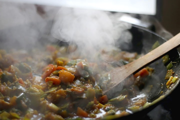 Stir- fry leek, carrot and squash with soy sauce, in a wok. Selective focus.
