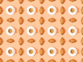 top view of fresh croissants on plates and coffee on orange, seamless background pattern