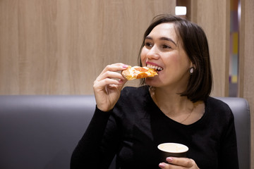 young woman eating pizza at a cafe