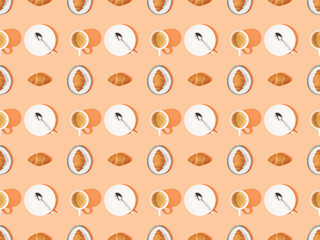 top view of spoons, fresh croissants on plates and coffee on orange, seamless background pattern