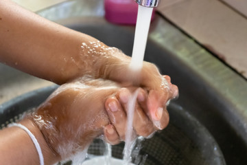 applying soap and washing both hands with clean running water 