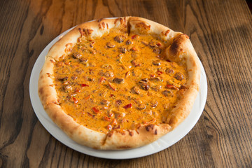 Pizza with cheese and beefsteak in mushroom sauce