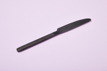 metal shiny black knife on violet background