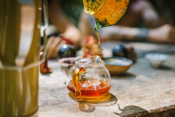 The atmospheric tea ceremony in the wooden table with the soft focused background. The warm natural light. 
