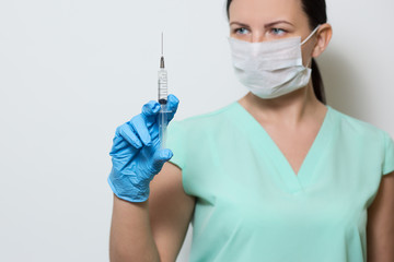 A girl with a medical syringe for injection.Laboratory medical worker in a mask