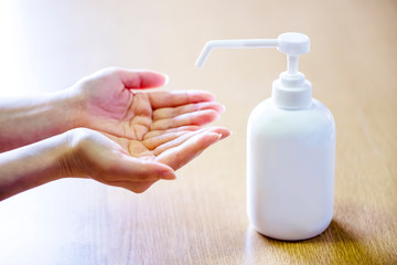 女性の手と消毒用ボトルとコピースペース
