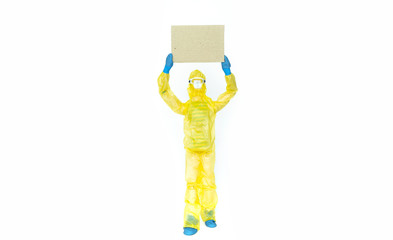 Toy man in hazmat suit holds a cardboard. Viral epidemic, biological, chemical, radioactive danger, mockup, copy space