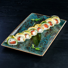 Sushi rolls on a black plate.