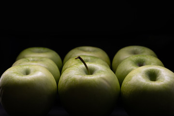 Green apples on a black background