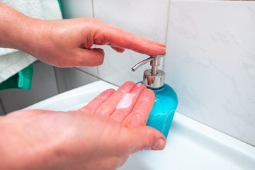 woman washes hands with soap