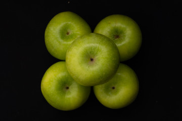 Green apples on a black background