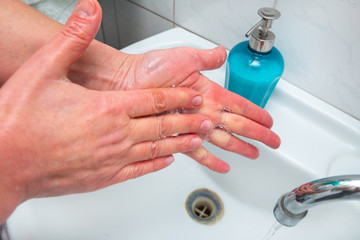 woman washes hands with soap