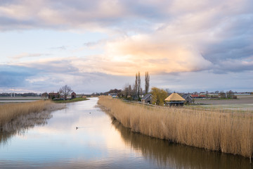 Scenic landscape view of dutch countryside at river Rotte, Netherlands at sunset