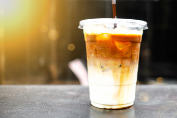 A close up view of iced caramel macchiato on a rusty table