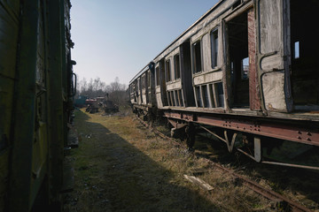 Fototapeta na wymiar Abandoned train depot with various trains and carriages in different states of decay.