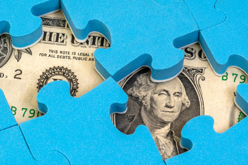 US dollar currency hidden under puzzle