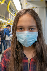 Fototapeta na wymiar Young tween girl wearing surgical mask on subway