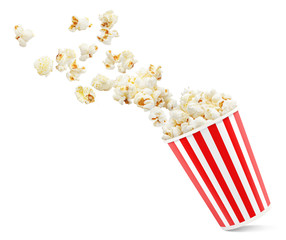 Popcorn flying out of red-white striped paper cup, isolated on white background