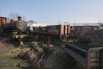 Abandoned train depot with various trains and carriages in different states of decay.