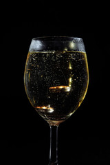 gold wedding rings in a glass, champagne