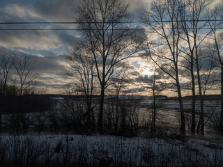 view from the train window on the nature of the Urals. blue sky snow and sun through the trees.