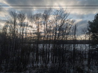 view from the train window on the nature of the Urals. blue sky snow and sun through the trees.