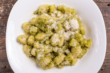 Italian homemade gnocchi with basil sauce and potatoes. Traditional dish of Italian cuisine, vegetarian food.