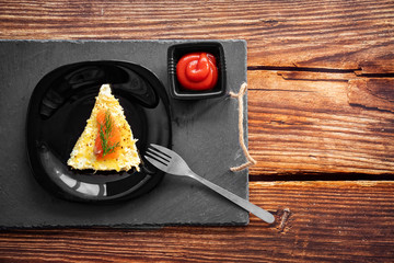 copy space. piece omelet black plate with ketchup.