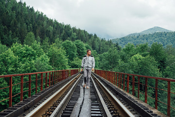 Fototapeta premium Young man in a gray tracksuit on a railway track.