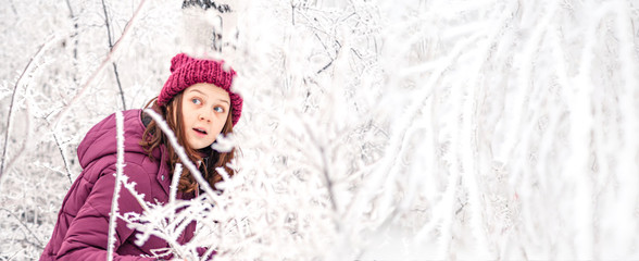Obraz premium Portrait Happy young teen girl under snowfall in winter forest