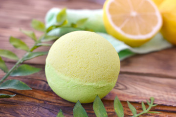 Close up aromatherapy spa design with bath bomb and leaves on wooden background. Fresh lemon...