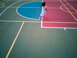Fototapeta premium Asian Toddler playing basketball at the basketball court in the evening.