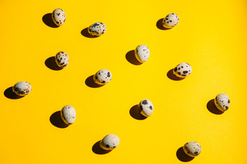 Quail eggs pattern on a yellow background top view