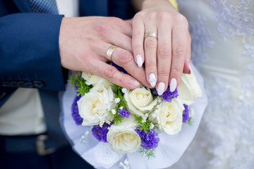 Hands and rings on wedding bouquet. wedding theme