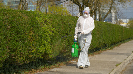Civil protection worker sprays the empty suburbs with antiviral sanitizer.