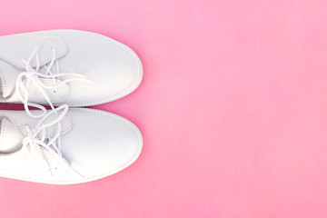 white sneakers on a pink background. top view. copyspace. place for text