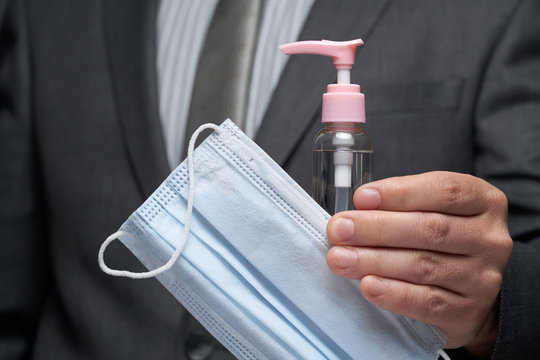 a man demonstrates a protective face mask for antivirus individual protection and bottle of sanitizer liquid- healthcare and medicine concept, prevention tips