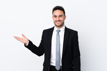 Young business man over isolated background holding copyspace imaginary on the palm