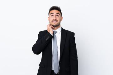 Young business man over isolated background thinking an idea