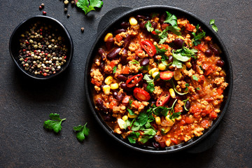 Chili con carne classic mexican dish on the kitchen table, top view.